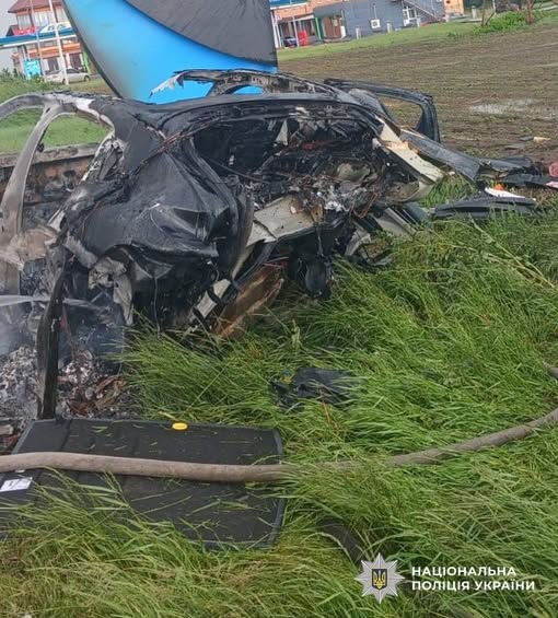 Спалений автомобіль Porsche Cayenne на узбіччі траси Київ-Одеса біля бетонної стели після смертельної ДТП, робота поліції на місці аварії