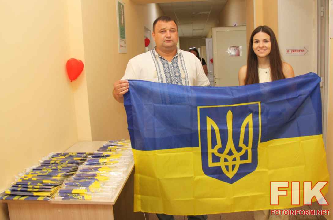 Волонтер Геннадій Шевченко вручає прапор України донору на станції переливання крові у Кропивницькому