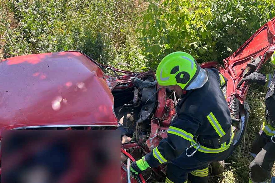Рятувальники ДСНС працюють на місці ДТП у Кіровоградській області, деблокуючи постраждалого з понівеченого автомобіля.