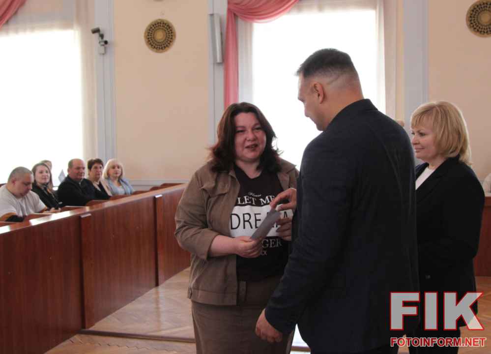 Секретар міськради Олег Колюка та Лариса Костенко вручають грошові сертифікати переможцям конкурсу Еко Варта у Кропивницькому.