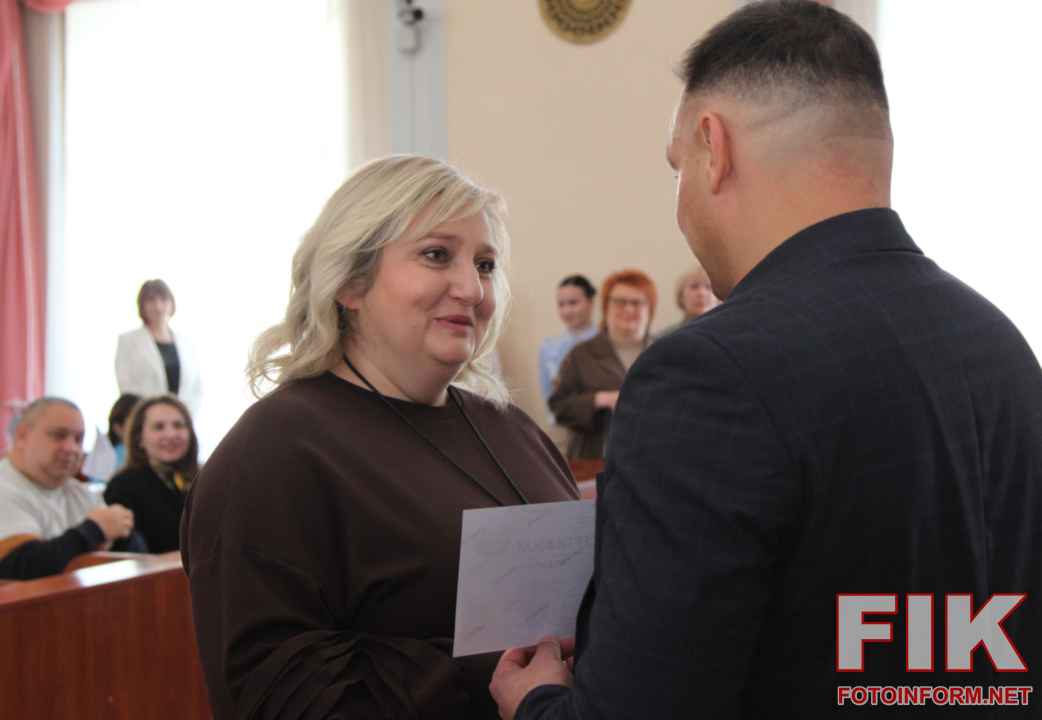 Секретар міськради Олег Колюка та Лариса Костенко вручають грошові сертифікати переможцям конкурсу Еко Варта у Кропивницькому.