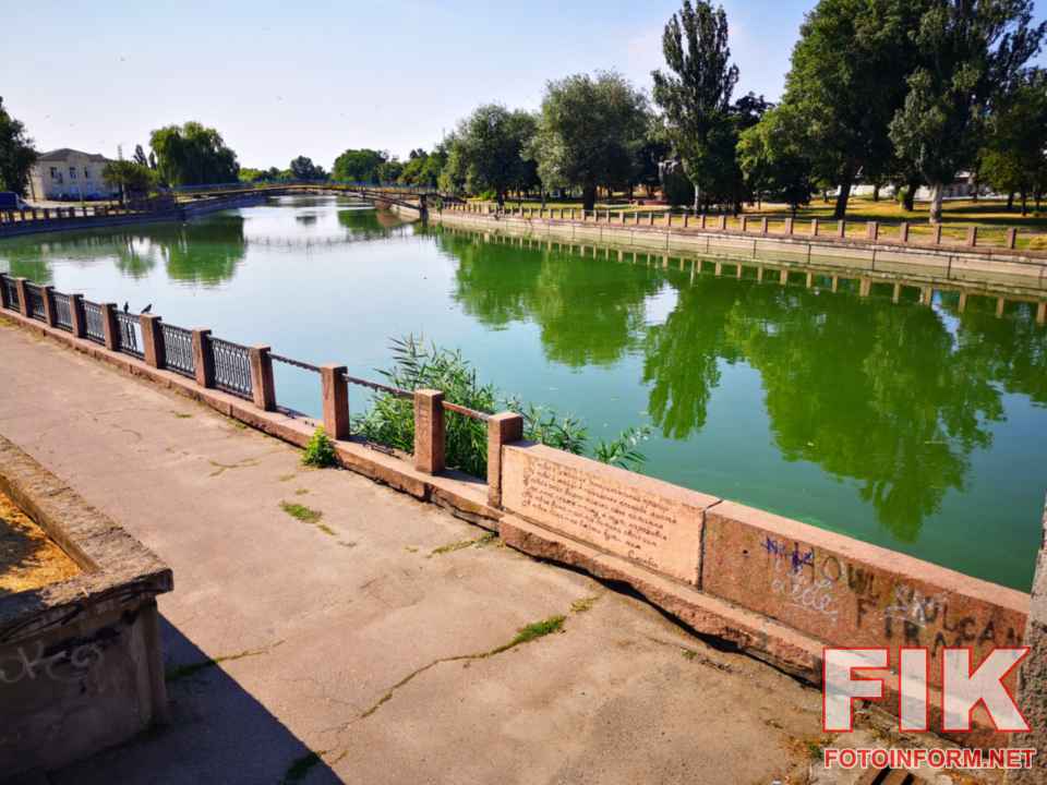 Зелена вода через цвітіння річки Інгул у Кропивницькому на тлі набережної.
