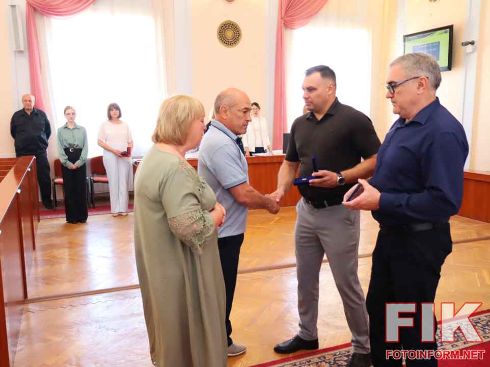Олександр Мосін та Олег Колюка вручають нагороду Янголам спорту батькам Павла Іщенка у Кропивницькій міськраді