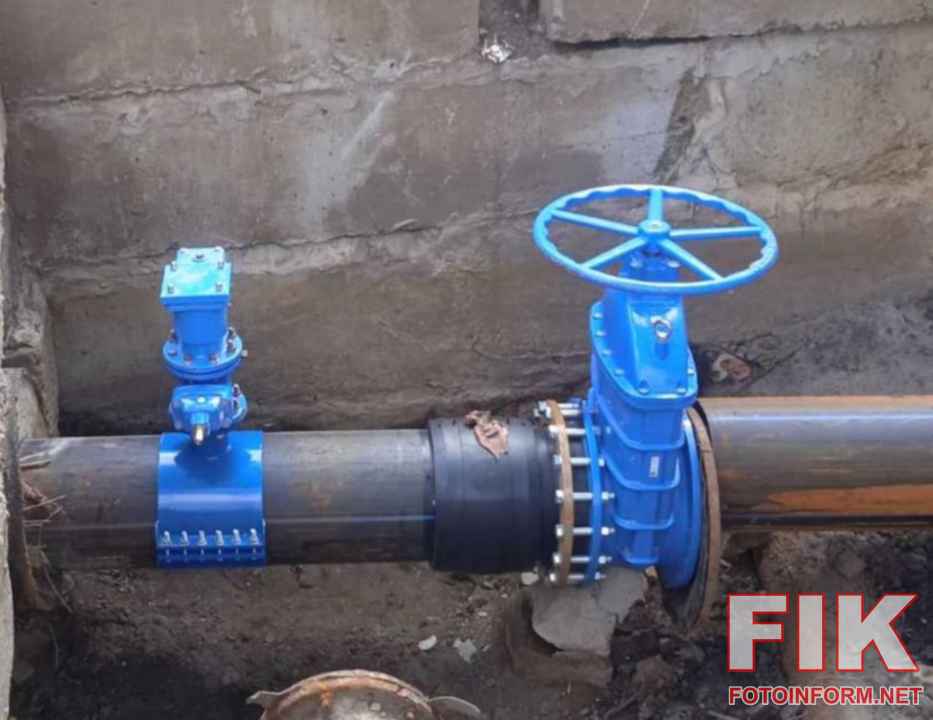 Спеціалісти аварійної служби водоканалу в спецодязі проводять ремонт підземного трубопроводу у розритій траншеї, усуваючи витік води.